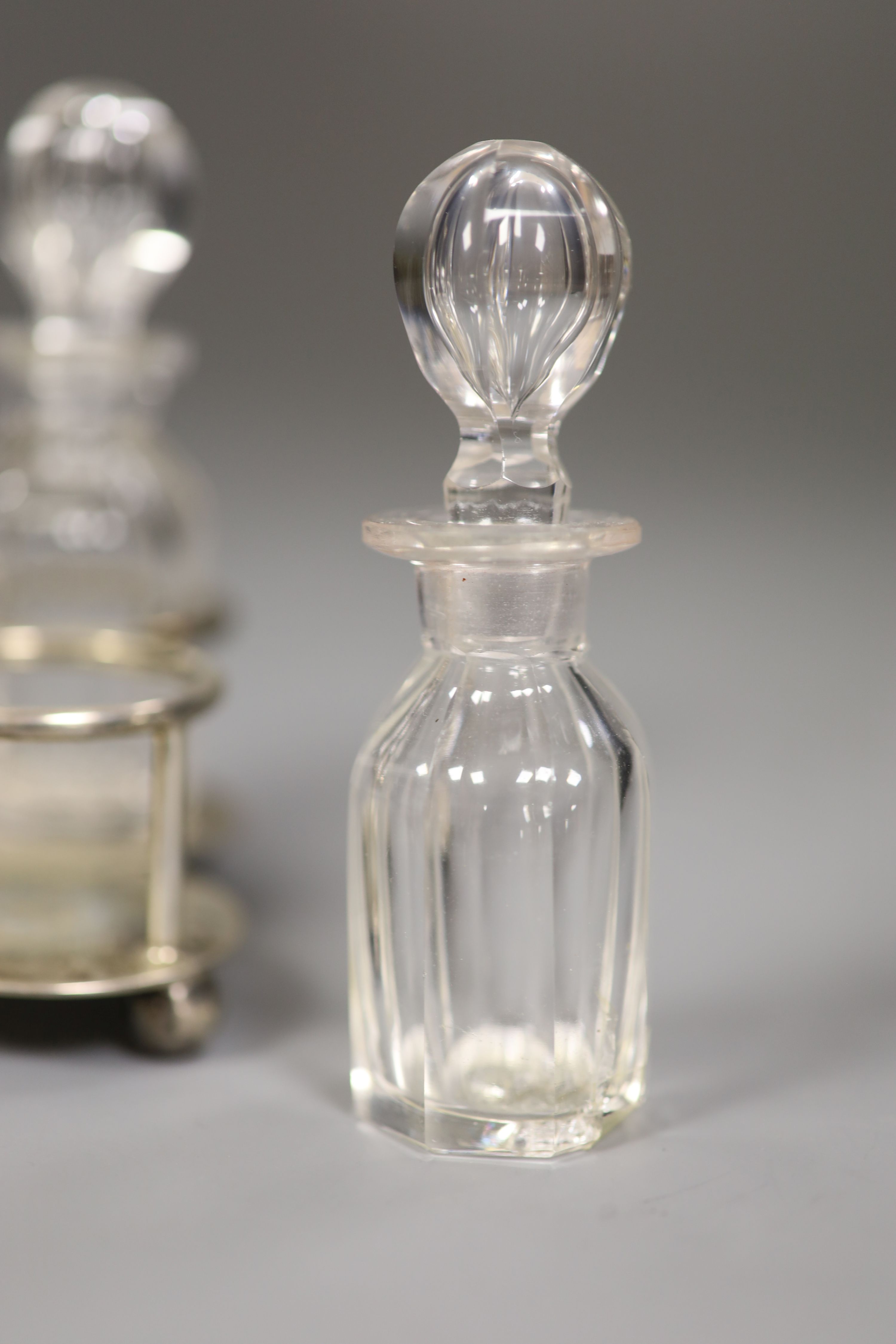 A small Edwardian silver cruet stand, with four glass cruets, Goldsmiths & Silversmiths Co Ltd, London 1901, height 12cm, 4oz.